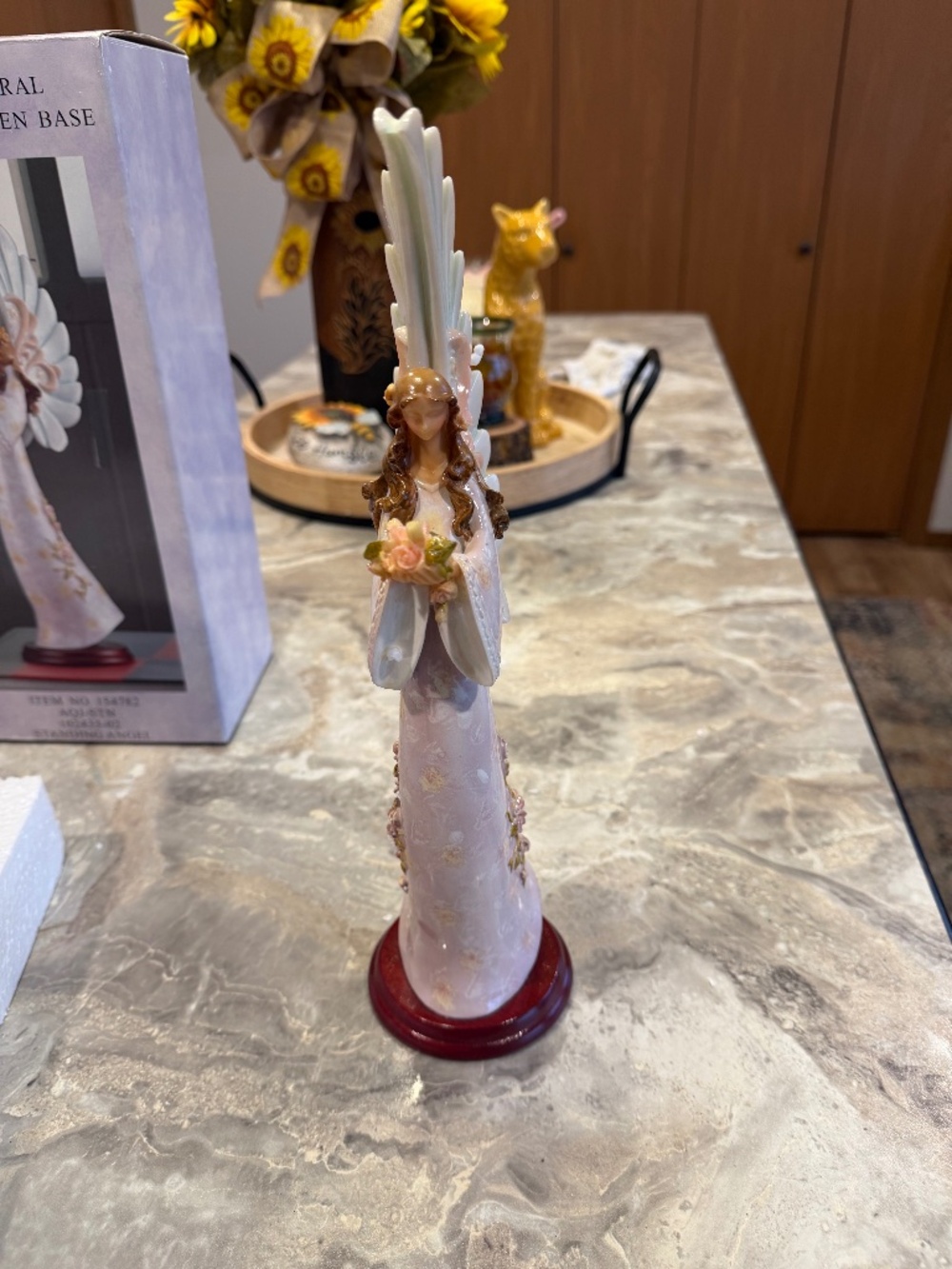 Vintage resin standing angel figurine with floral accents on a wooden base